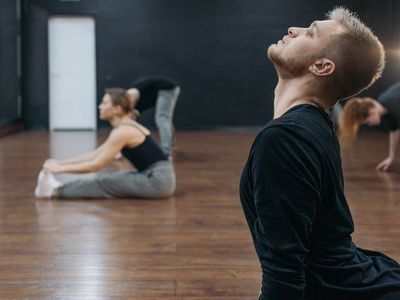 Person performing a side stretch in dark lighting.
